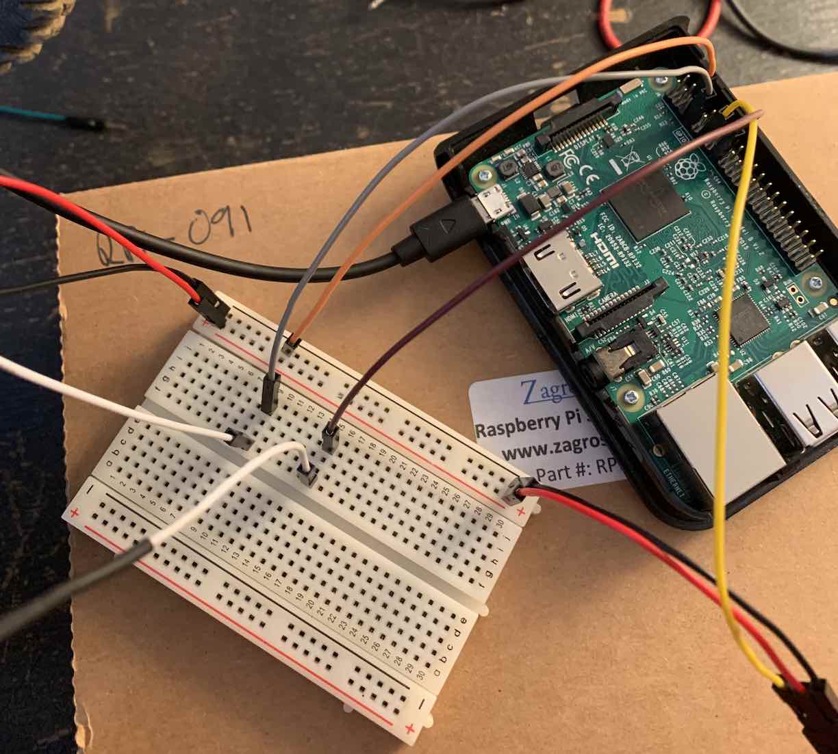 a raspberry pi and breadboard with cables all over the place